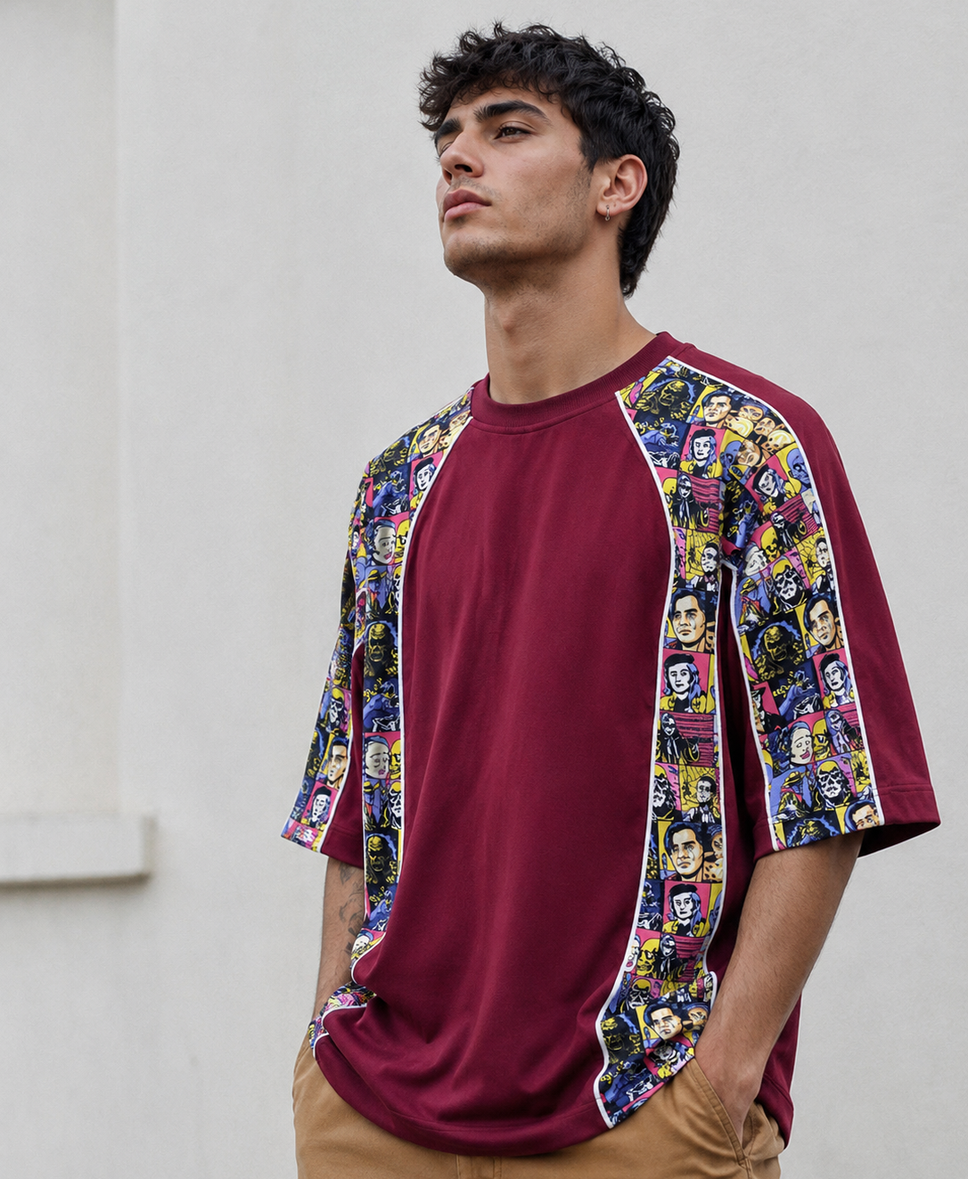 Man wearing a burgundy baseball shirt with colorful graphic sleeves against a neutral background