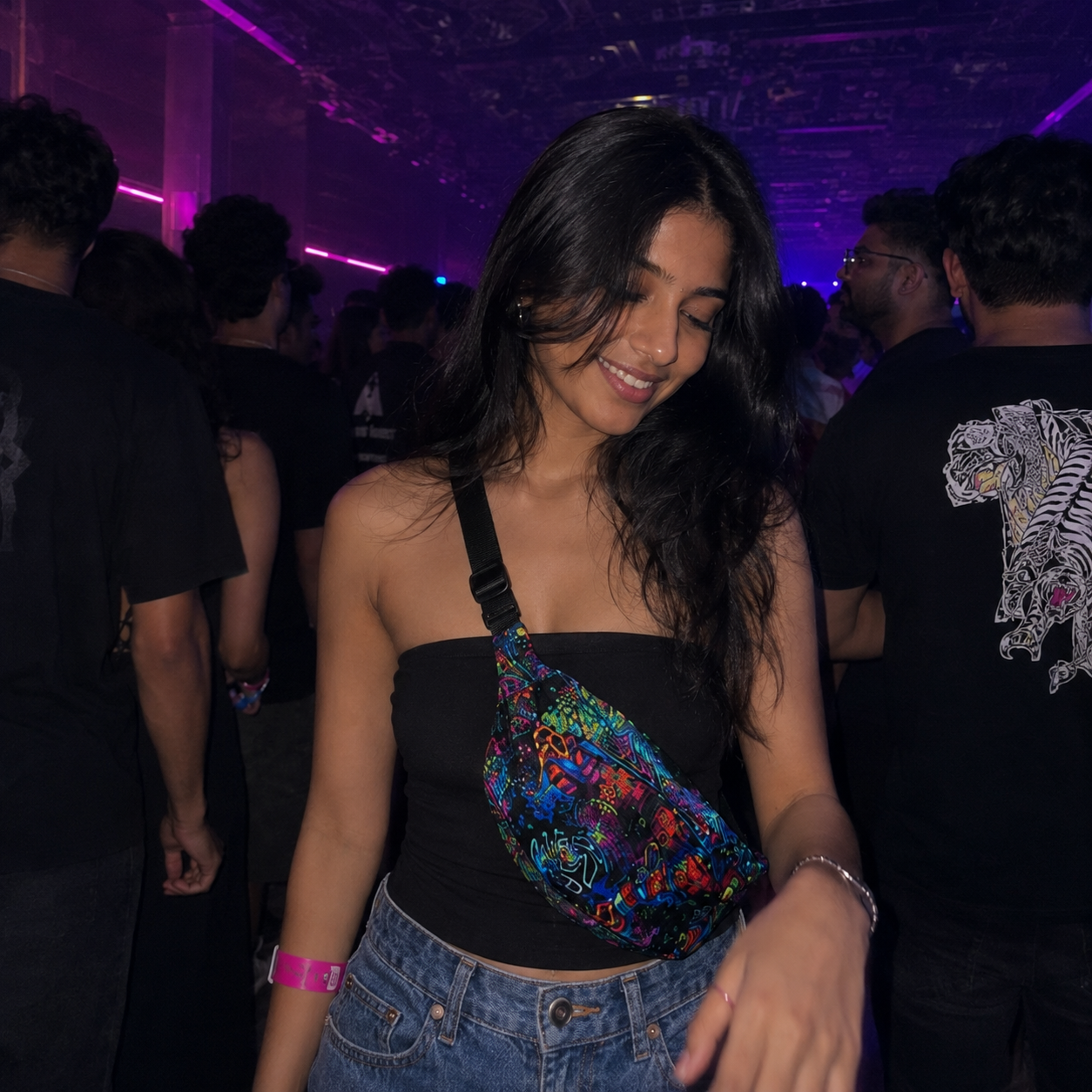 Woman at a party with colorful bag and purple lighting