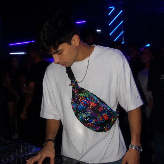 Person wearing a colorful fanny pack in a dark, possibly nightclub setting