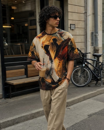 Person wearing a colorful shirt and beige pants walking on a city street.