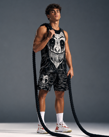 Man holding battle ropes against a gray background