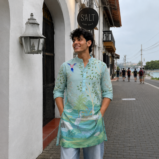 Man wearing a light blue floral shirt standing on a street with a 'Salt' sign in the background.