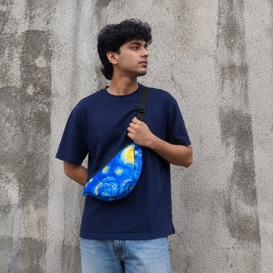 Person wearing a blue fanny pack with a starry night design against a textured wall.
