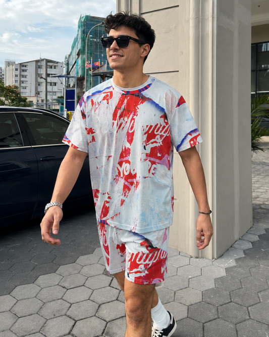 Man wearing a red, white, and blue tie-dye outfit walking outdoors.