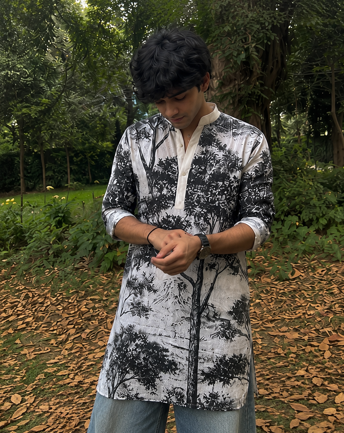 Person wearing a black and white tree-patterned shirt in a forest setting