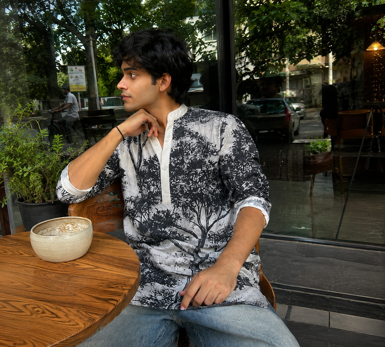 Person sitting at a table in an outdoor cafe setting
