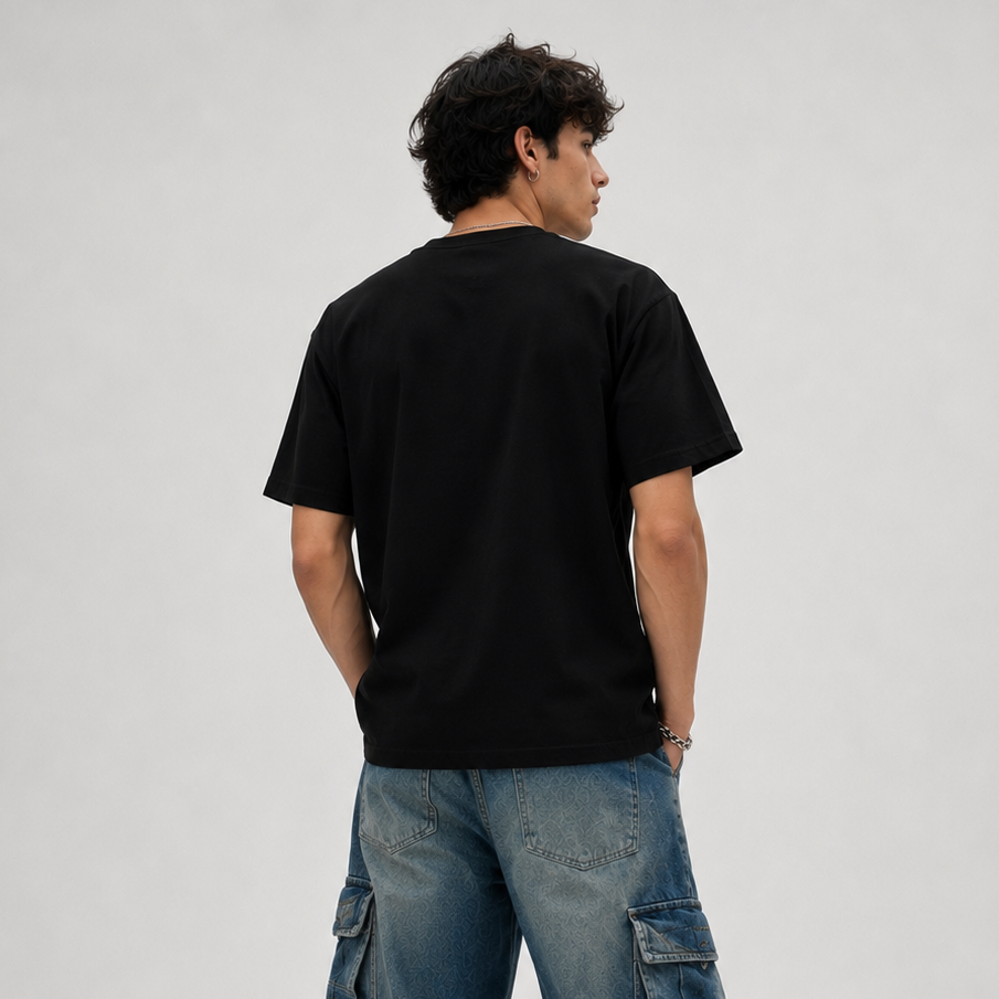 Person wearing a black t-shirt and blue cargo pants on a white background
