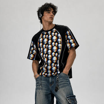 Person wearing a patterned shirt and baggy jeans on a plain background