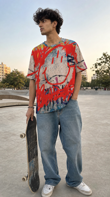 Person wearing a colorful tie-dye shirt and jeans holding a skateboard in an outdoor setting.